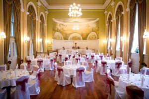 Hall full of tables and chairs prepped for a wedding