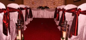 Chairs with white overlay and red ribbons