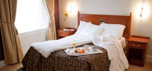 Double bed with breakfast and a gown on it