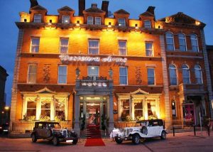 Front of Westenra Arms Hotel with 2 cars parked alongside the red carpet