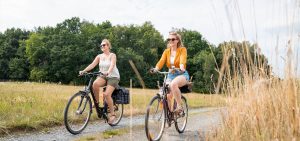 2 females cycling on a gravel road