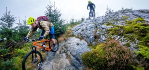 2 guys cycling down some rocks