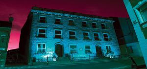 Front of museum with a blue light shining on it