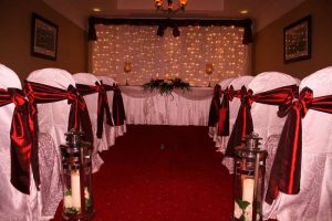 Decorated white chairs with red ribbons