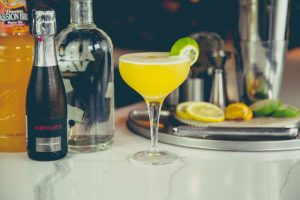 Yellow cocktail with a lime wedge