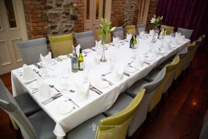 long dinner table with cutlery and wine glasses